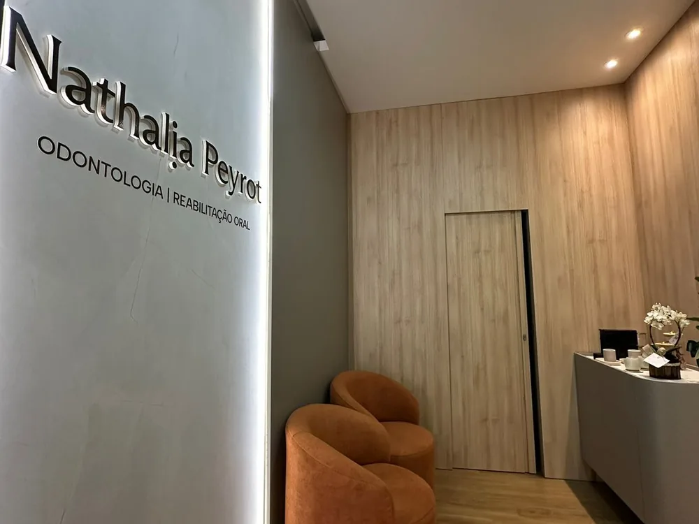 Recepção da clínica, com o logotipo na parede